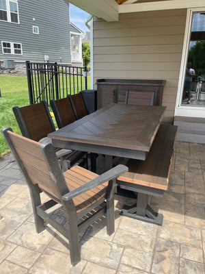 Trestle X Outdoor Bench by Wooden Whale Workshop, dark wood slats with black metal frame on a patio dining set.