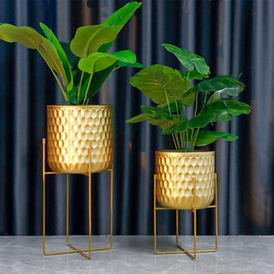 JHY DESIGN two gold hammered metal planters on matching gold stands, 17-inch and 12-inch tall, with leafy greens.
