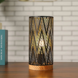 11'' High battery-powered metal lamp with black perforated shade and wooden base, emits warm light.