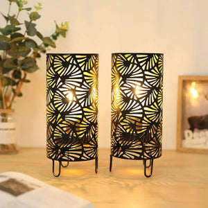 9-inch high metal lamp set of 2; black cylindrical lamps with intricate cutout pattern, battery-powered.