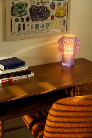 Oppi Table Lamp with purple ribbed glass base on a wooden table.
