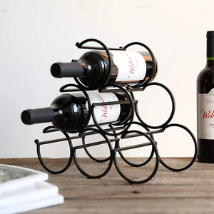 Iron tabletop wine rack in black metal holding 2 bottles horizontally