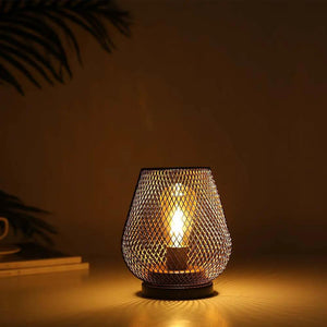 6.7-inch tall battery-powered outdoor table lamp with a metal mesh shade and warm amber glow.
