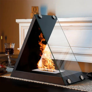 Glass tabletop fireplace by JHY DESIGN, triangular metal frame with clear glass panels and gel-ethanol flame