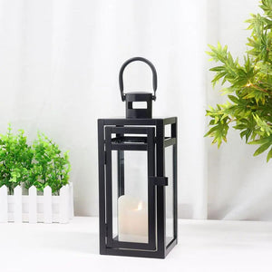12'' high black metal decorative candle lantern by JHY DESIGN with glass panels and a lit candle inside