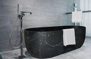 Alexandrette black marble bathtub, hand-carved from solid marble block, freestanding oval design.