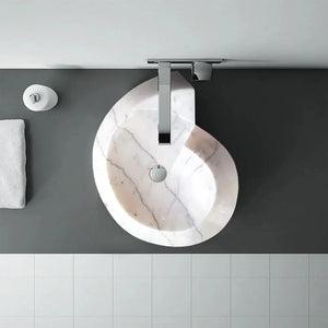 Carrara Marble helix-shaped above-vanity bathroom sink with polished finish and chrome faucet.