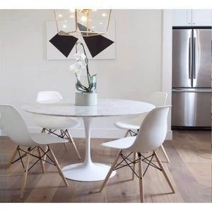 Round marble dining table by Villohome, polished surface with eased edge, white molded chairs with wooden legs