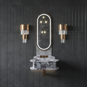 Bathroom fluted marble vessel sink mounted on a dark wall with a backlit oval mirror and copper accents.