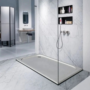 Shell Stone limestone shower base, rectangular hand-carved from solid block; 36x48 inches in a glass-enclosed shower.