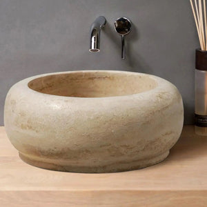 Light beige travertine stone bathroom sink bowl on wood vanity with chrome faucet