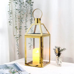 16-inch high decorative lantern with rose-gold metal frame and glass panels, candle glow inside