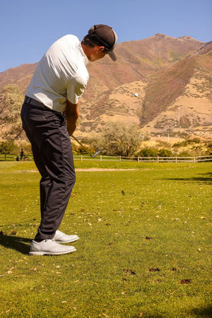 Ase 3-Piece Wedge Set on a golf course; golfer in white shirt swings with hills in background
