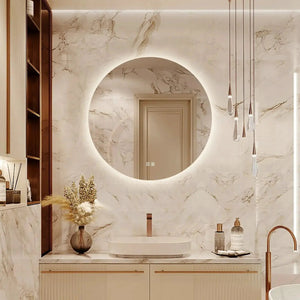 Round backlit LED bathroom vanity mirror with dimmable lights, mounted on a marble wall above a sink.
