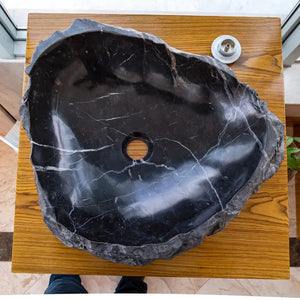Toros Black natural stone marble vanity sink; rustic black round basin with white veining on wood table