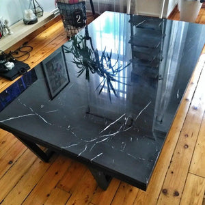 Marble coffee table with a rectangular polished black top and black metal legs