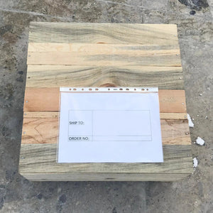 Toros end/side table components; multiple natural wood boards stacked on a workshop floor with a shipping form