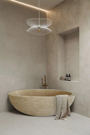 Troia Light Travertine Bathtub, beige oval stone tub with smooth hand-carved finish for a luxurious bathroom look