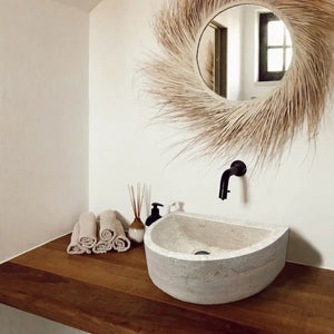 Troia Light Travertine half-round wall-mount bathroom sink by Villohome 10x16x6 on wooden counter with black faucet.