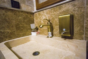 Troia Light Travertine stand-alone bathroom sink by Villohome, honed beige travertine with bronze faucet.