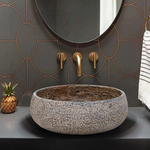 Valencia travertine above-counter bathroom sink; round gray speckled stone basin