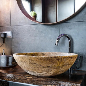 Valencia travertine natural stone oval vessel bathroom sink beige with veining on dark wood counter chrome faucet