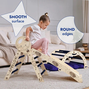 Apollo 4in1 climbing set in natural wood with navy accents, toddler climbs the Pikler-style frame indoors on a rug.