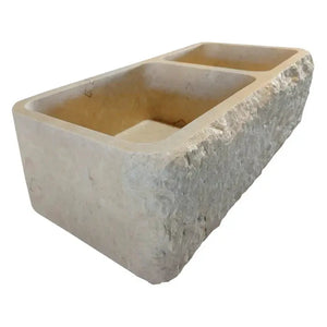 Botticino beige marble farmhouse apron kitchen sink with two basins and rough exterior.