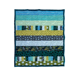 Quilt Kit Bricks and Beams Dinosaurs by Block Party Quilt Co; fabric-strip quilt kit in teal, blue, and green.