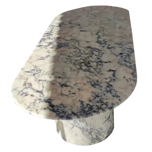 Calacatta Viola marble oval dining table with polished finish and pedestal base.