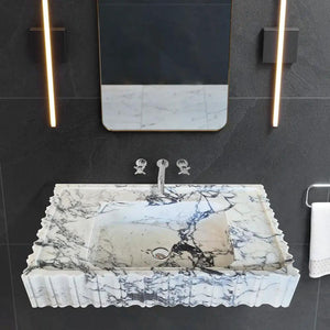 Calacatta Viola marble wall-mount vanity sink, U-shaped with fluted edges.
