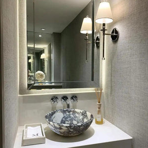 Calacatta Viola marble vessel sink by Villohome on a white countertop with wall-mounted faucet and illuminated mirror.