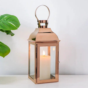 12.5in high decorative lantern by JHY DESIGN with rose-gold copper finish, glass panels, and lit candle.