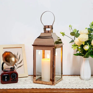 12.5” High decorative lanterns by JHY DESIGN with copper finish, glass panels, and a lit candle inside.