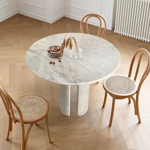 Carrara white marble round dining table with round marble legs, 48in dia, 36in h, with four caned-seat bentwood chairs
