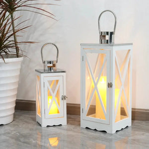 Set of 2 white rectangular farmhouse wooden candle lanterns with glass panels, metal handles and glowing candles.