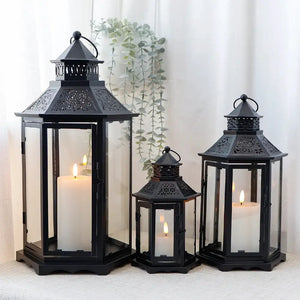 Decorative candle lanterns: set of 3 black hexagonal lanterns with glass panes and metal frames, heights 18in, 13in and 10in.