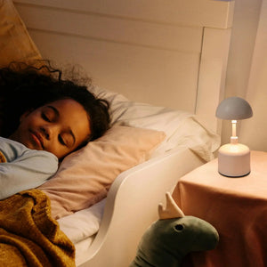 Set of 2 rechargeable mushroom lamps; cordless bedside lights with gray caps and white bases beside a sleeping person.