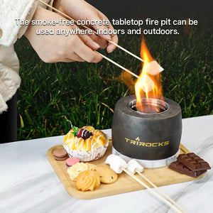 Black graphite cement portable fireplace by TRIROCKS; gel/ethanol tabletop heater on a wooden tray with desserts.