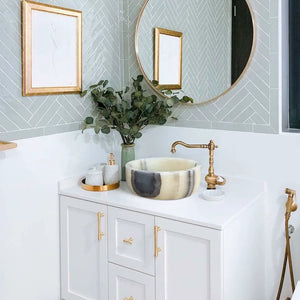 Stone sink Villohome green translucent onyx bathroom vessel atop a white vanity with brass faucet