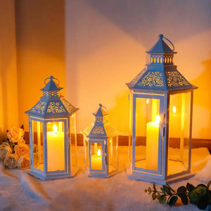 Set of 3 white hexagonal decorative lanterns with candlelight; vintage metal frames, heights 18, 13 and 10 inches.