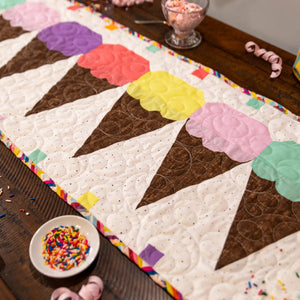Ice Cream Cones Table Runner Precut Quilt Kit; multicolor scoop blocks on a white/brown quilt with a rainbow border