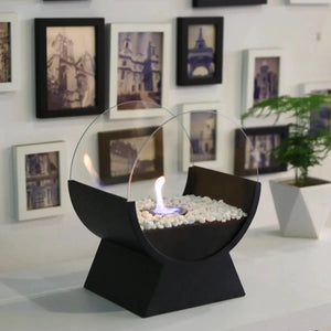 13.5-inch tall portable tabletop fireplace by JHY DESIGN with a circular glass guard and white stones.