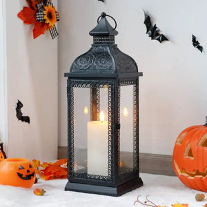 19-inch high rustic black metal candle lantern with ornate lattice glass panels and a lit candle