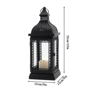 Rustic black metal candle lantern with ornate lattice panels and a candle inside, 13in tall.