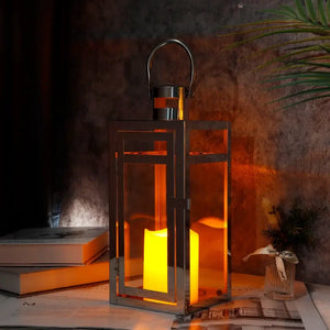 12'' High silver metal decorative candle lantern with glass panels and top handle for hanging or tabletop display.