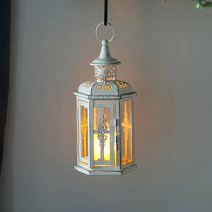 10-inch vintage-style hanging metal lantern candleholder in distressed white with a warm candle glow