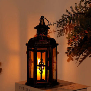 12-inch metal candle lantern in black with gold brush finish, candle glowing inside