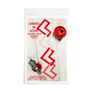 Linked Hearts Quilted Table Runner pattern by Block Party Quilt Co; fabric with red linked heart motif.