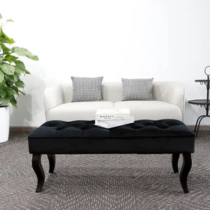 Black Dutch velvet ottoman bench with tufted top and curved legs.